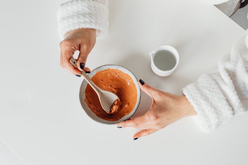 Homemade natural DIY face masks made from turmeric, honey, and oatmeal displayed on a white table for glowing skin